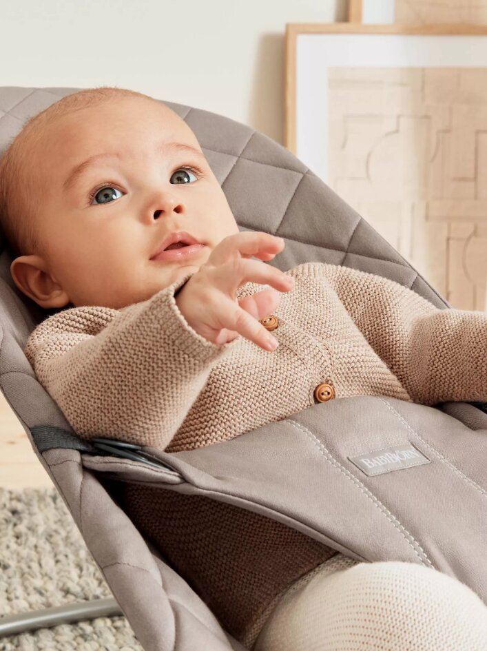 BabyBjorn Balansoar Bliss Sand Grey din tesatura matlasata cu aspect clasic cu bara de jucarii