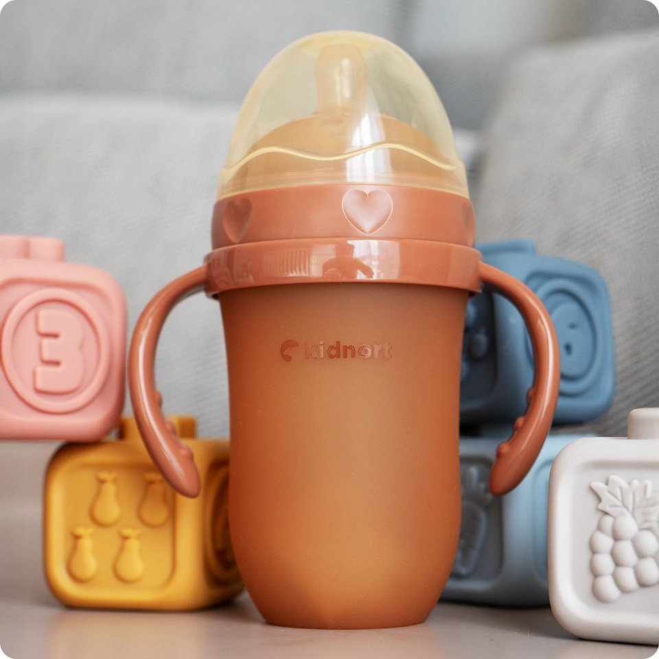 Kidnort Biberon anti-colici pentru bebelusi de la 6 luni Eple nivelul de debit 5 cu pai moale din silicon si biluta gravitationala incorporata maner ergonomic detasabil capacitate 250 ml Brown