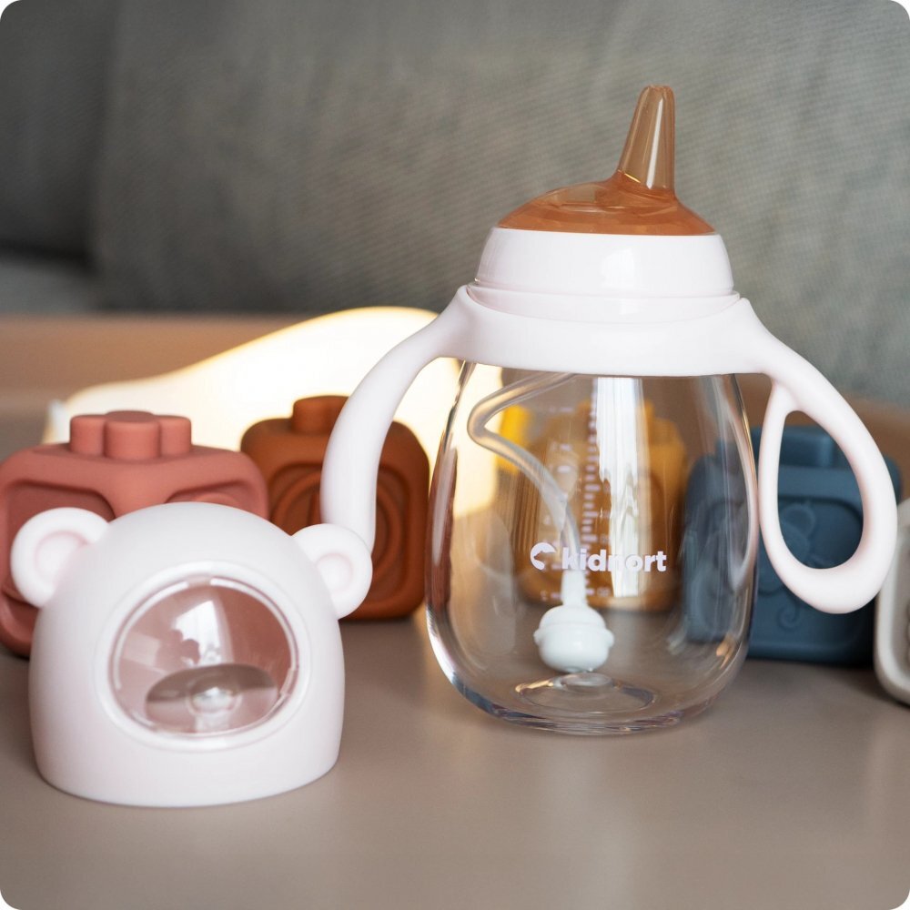 Kidnort Biberon cu tetina anti-colici debit variabil Jordbaer Pink 300 ml de la 6 luni echipat cu Pai cu bila gravitationala si maner ergonomic detasabil
