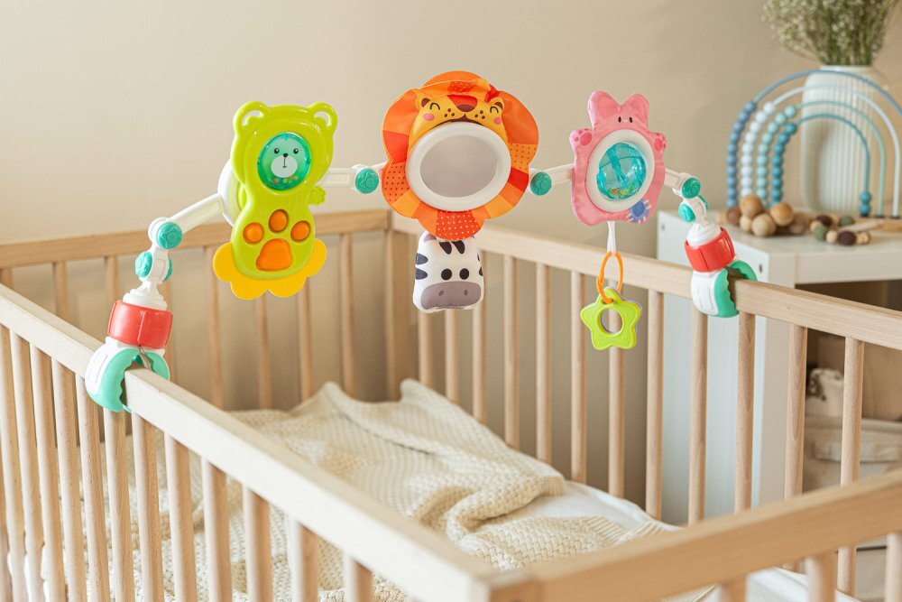 Toyz by Caretero Arcada senzoriala cu jucarii pentru caruciorpatutscaun auto copii Toyz Lion cu zornaitori oglinda si jucarii gingivale prindere universala